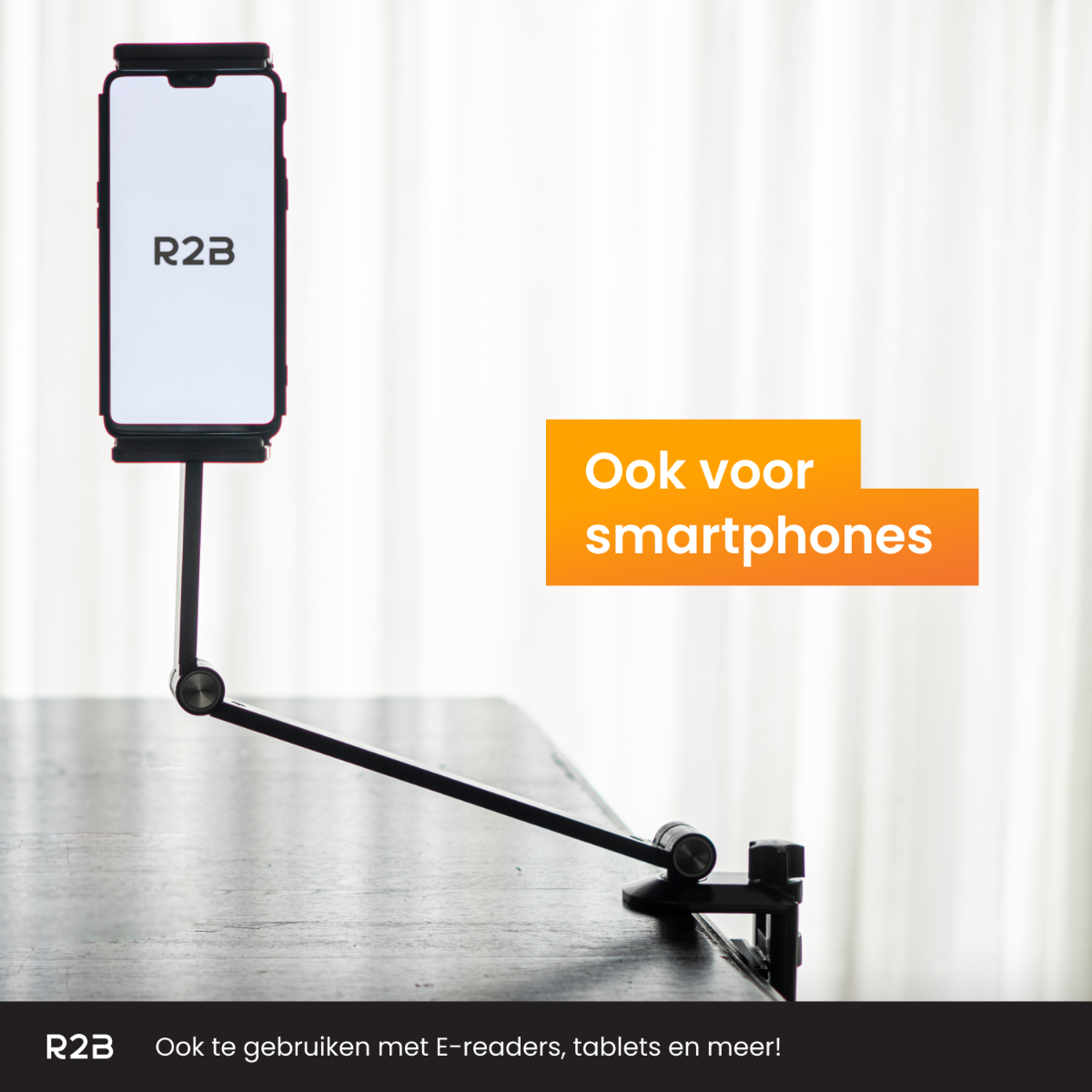 Ein schwarzer Telefonhalter mit einem Telefon. Text in Orange. Dunkler Holztisch, heller Hintergrund.
