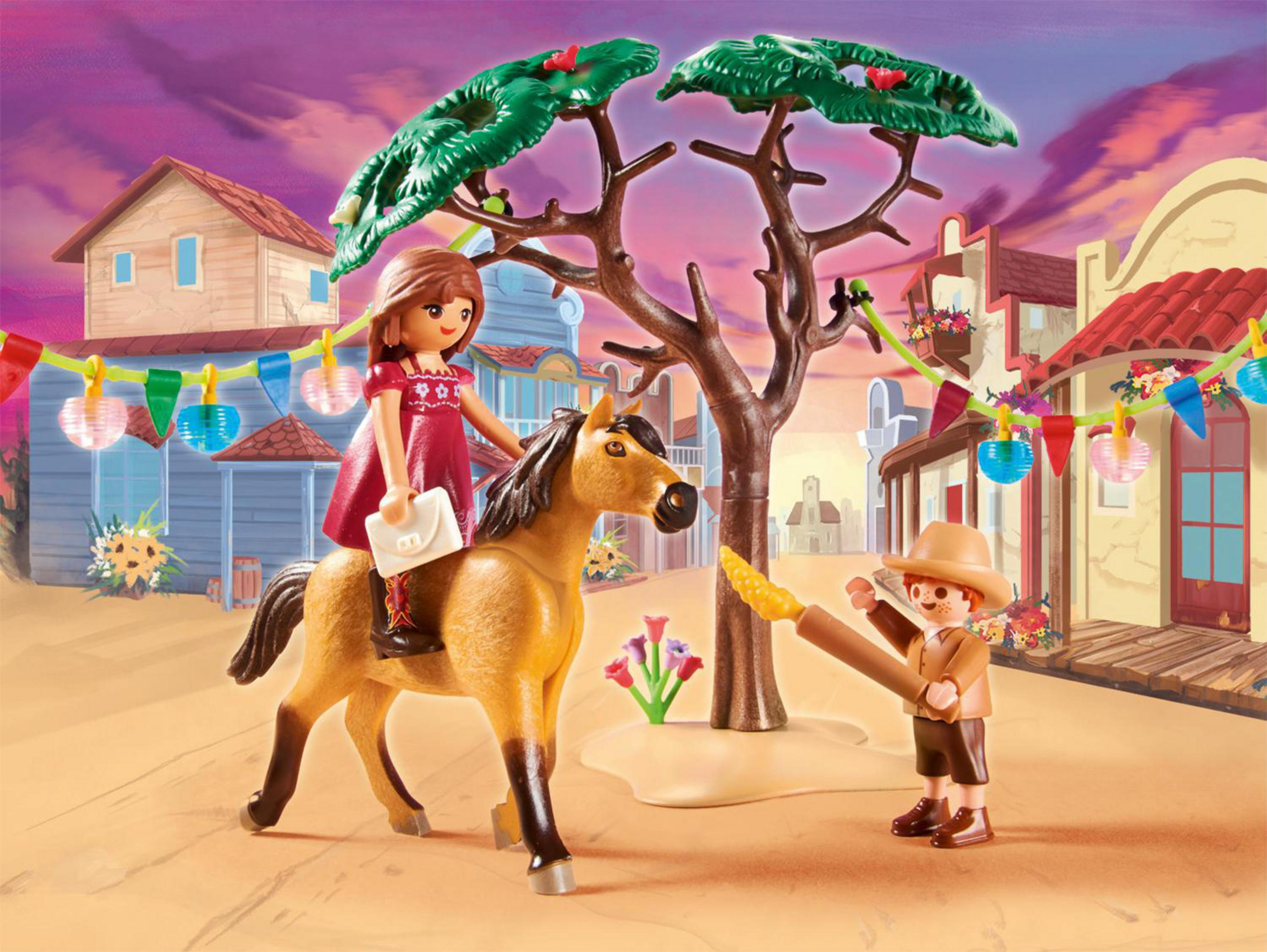 Escena del oeste de Playmobil: niña a caballo, vaquero con lazo, pueblo y telón de fondo del atardecer.