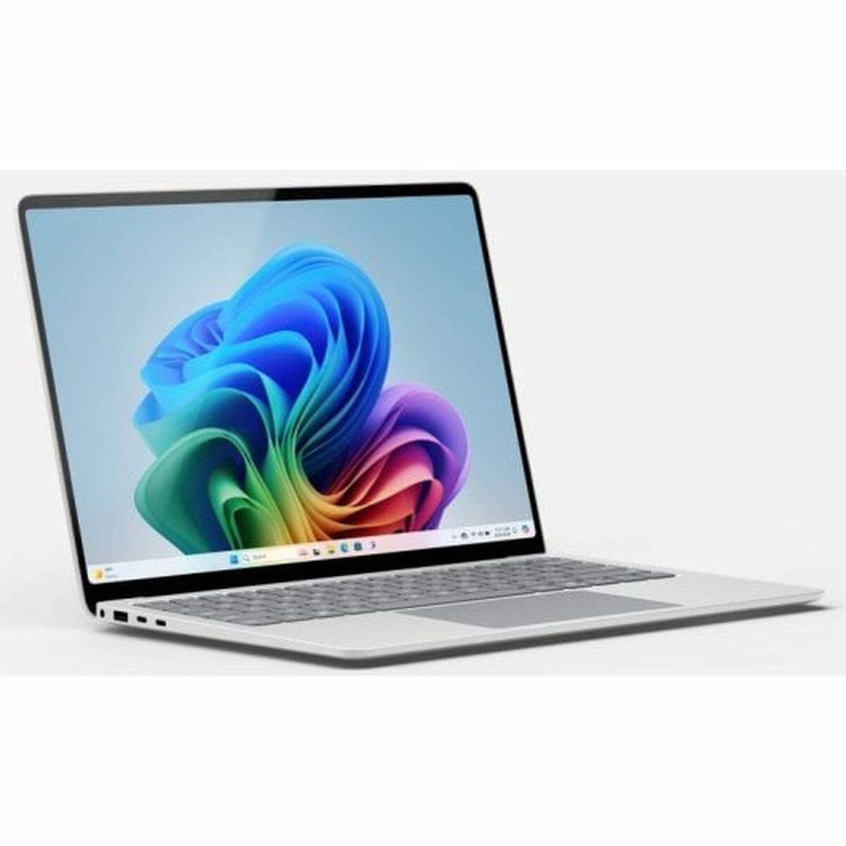 Un portátil plateado muestra una imagen abstracta colorida en su pantalla, abierto sobre una superficie blanca.