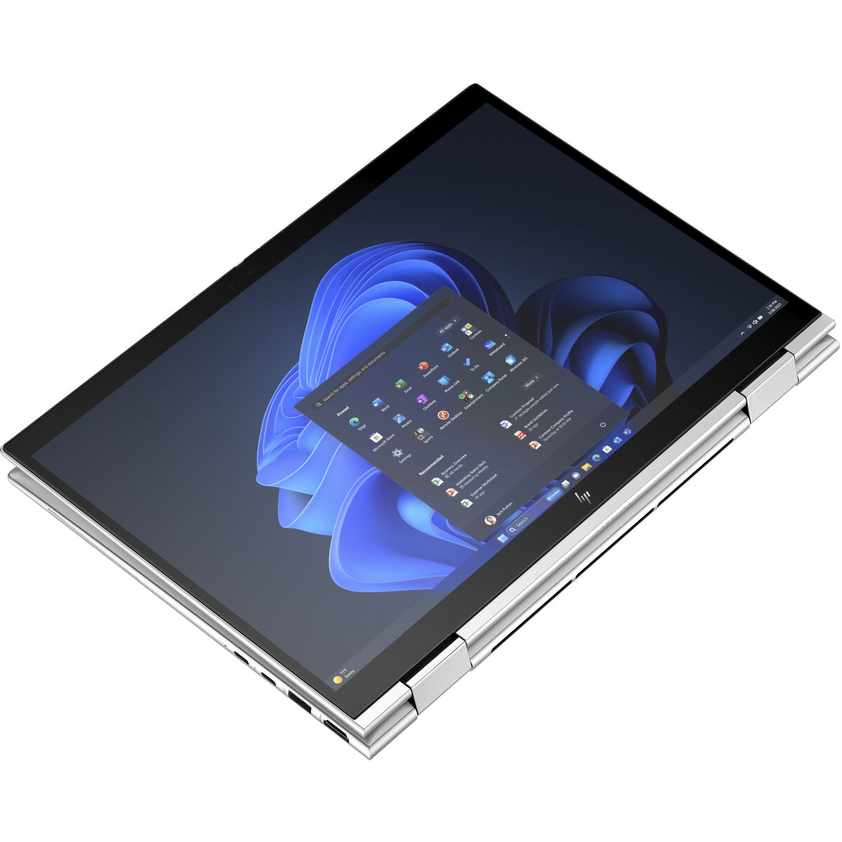 Un portátil plateado sobre una superficie blanca, pantalla mostrando la interfaz de Windows. Abierto.