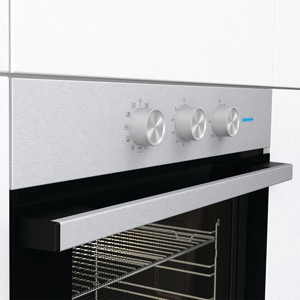 Un pannello di controllo del forno con manopole argentate, che mostra icone e numeri. Lo sfondo è bianco.