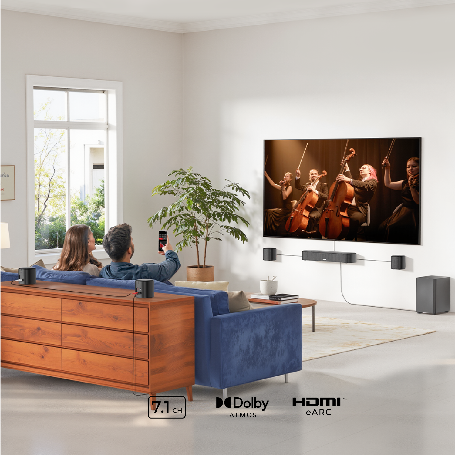 Woonkamer met mensen die tv kijken. Geluidssysteem met luidsprekers. Een blauwe bank en een plant.