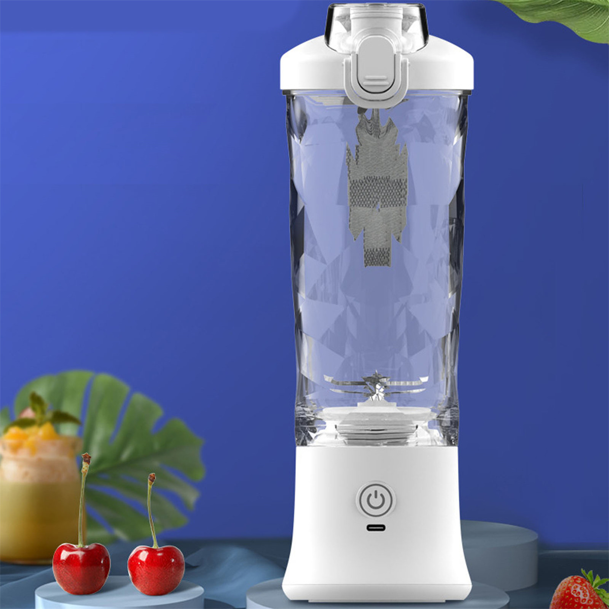 Ein weißer Mixer mit transparentem Behälter, Kirschen und einem Smoothie-Glas auf blauem Hintergrund.
