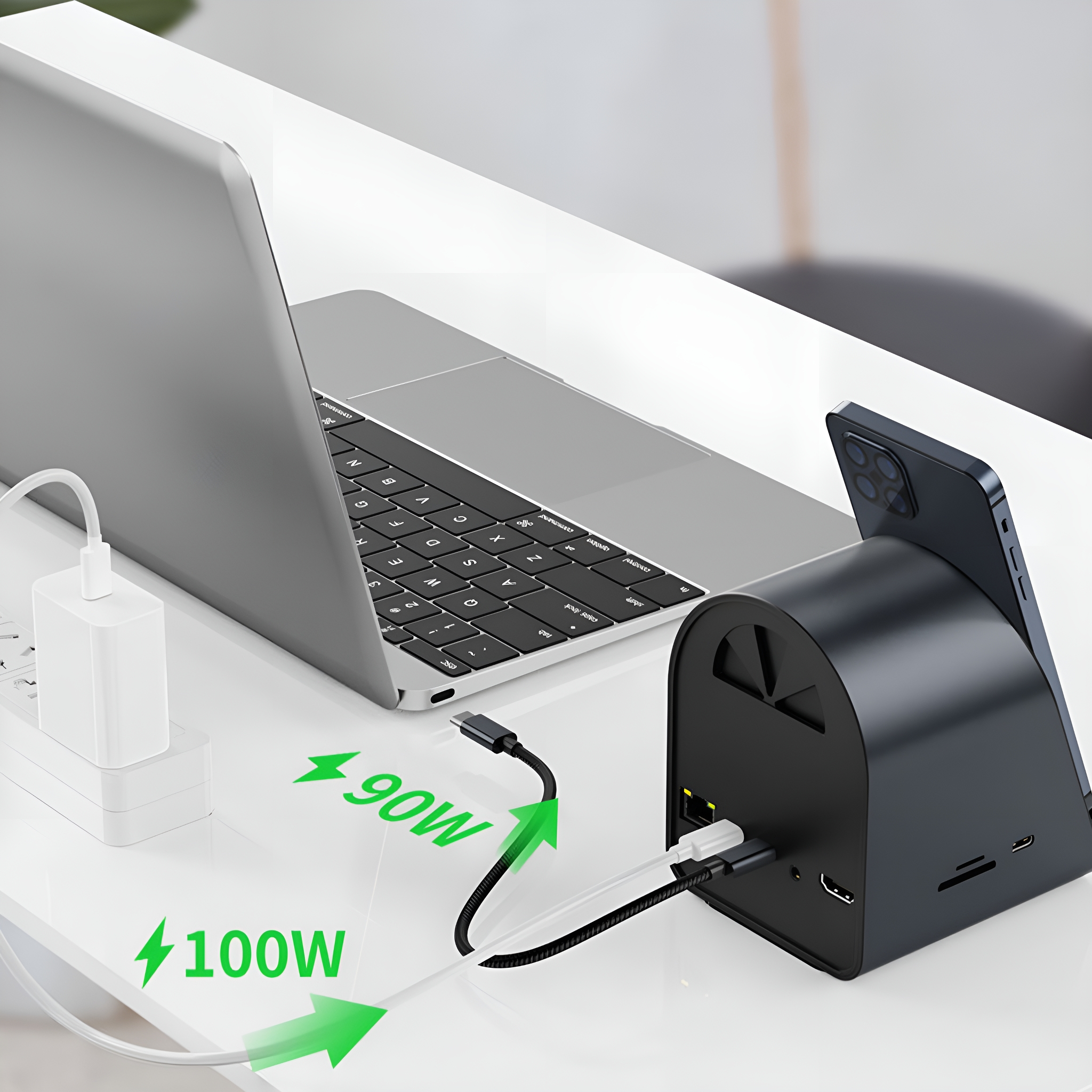 Ein Laptop, Telefon und eine Ladestation mit 90W und 100W Strompfeilen.