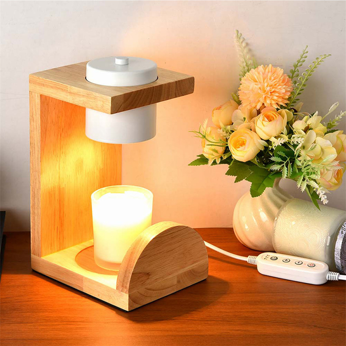 Kerzenhalter aus Holz mit brennender Kerze, Blumen und Ein-/Aus-Taste auf dem Holztisch.
