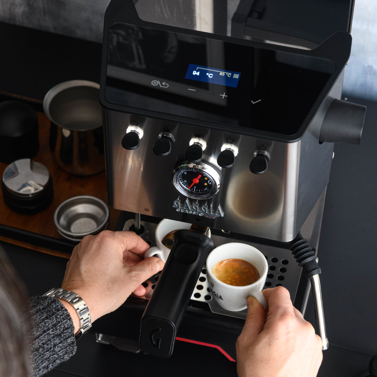 Espressomaschine, die zwei Tassen befüllt. Die Maschine ist silber und schwarz.