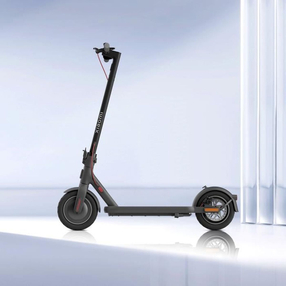 Trottinette électrique Xiaomi noire. Elle est sur un fond clair. La trottinette est droite et montre des détails.