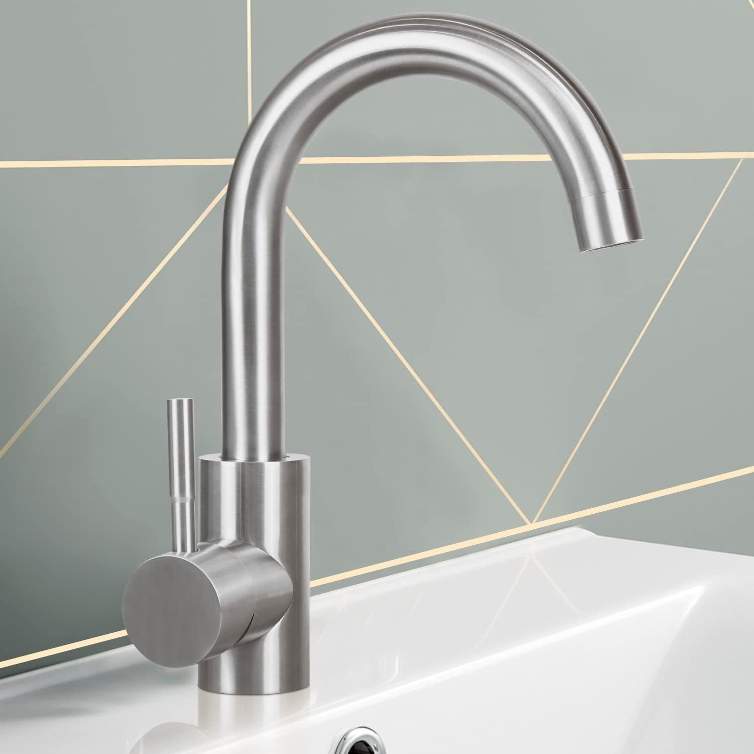 Edelstahl-Wasserhahn über weißem Waschbecken, geometrischer Hintergrund.