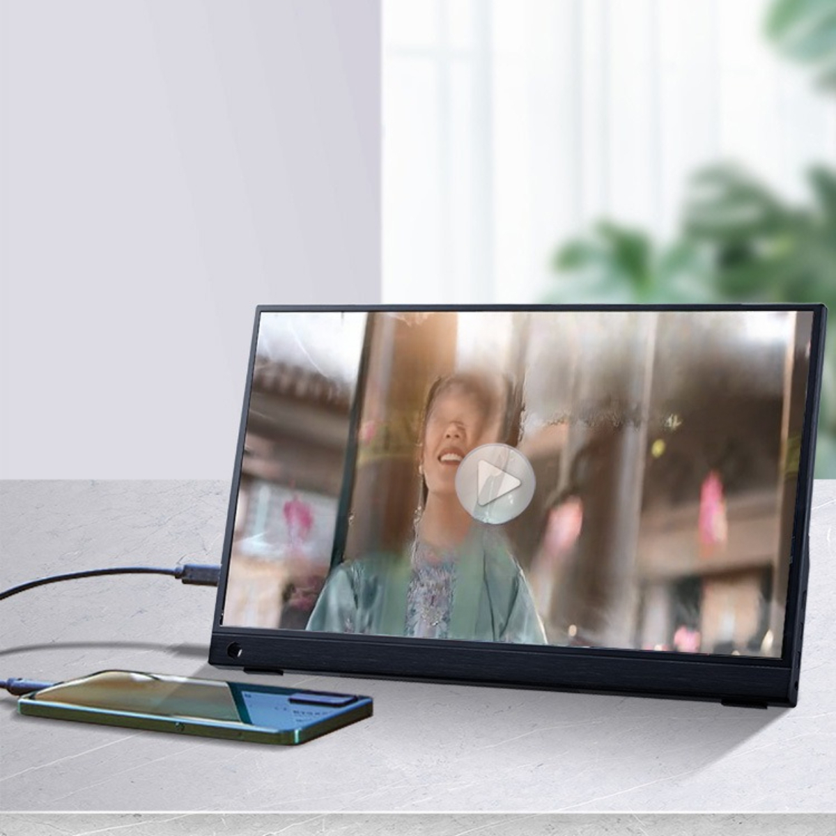 Ein tragbarer Monitor zeigt ein Video an. Auf dem Tisch neben dem Monitor liegt ein Smartphone.