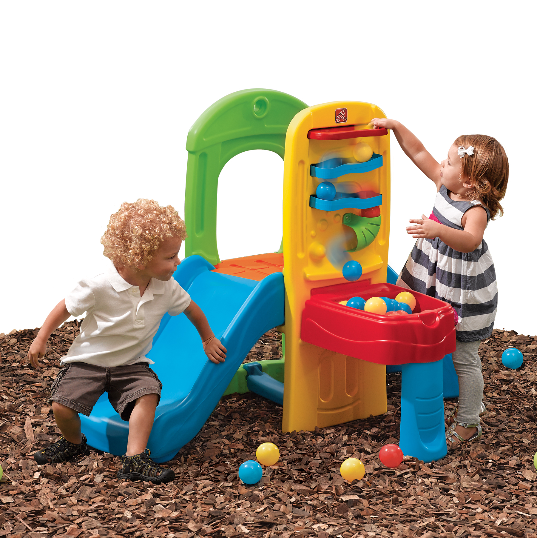 Zwei Kinder spielen auf einer bunten Rutsche und Spielstruktur mit Bällen am Boden.