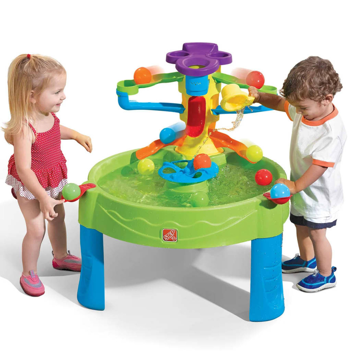 Zwei Kinder spielen mit einem Wassertisch. Der Tisch hat eine grüne Basis und ein Wasserspiel mit Bällen.