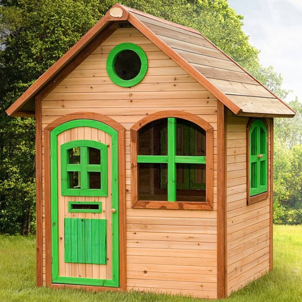 Spielhaus aus Holz mit grüner Tür, Fenstern und Verkleidung.