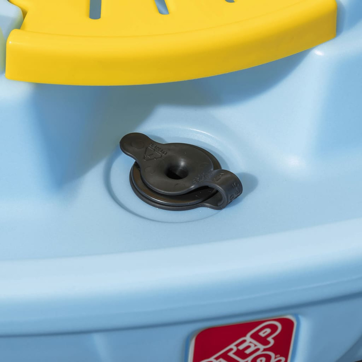 Nahaufnahme einer blauen Babybadewanne mit gelbem Rand und Abfluss.