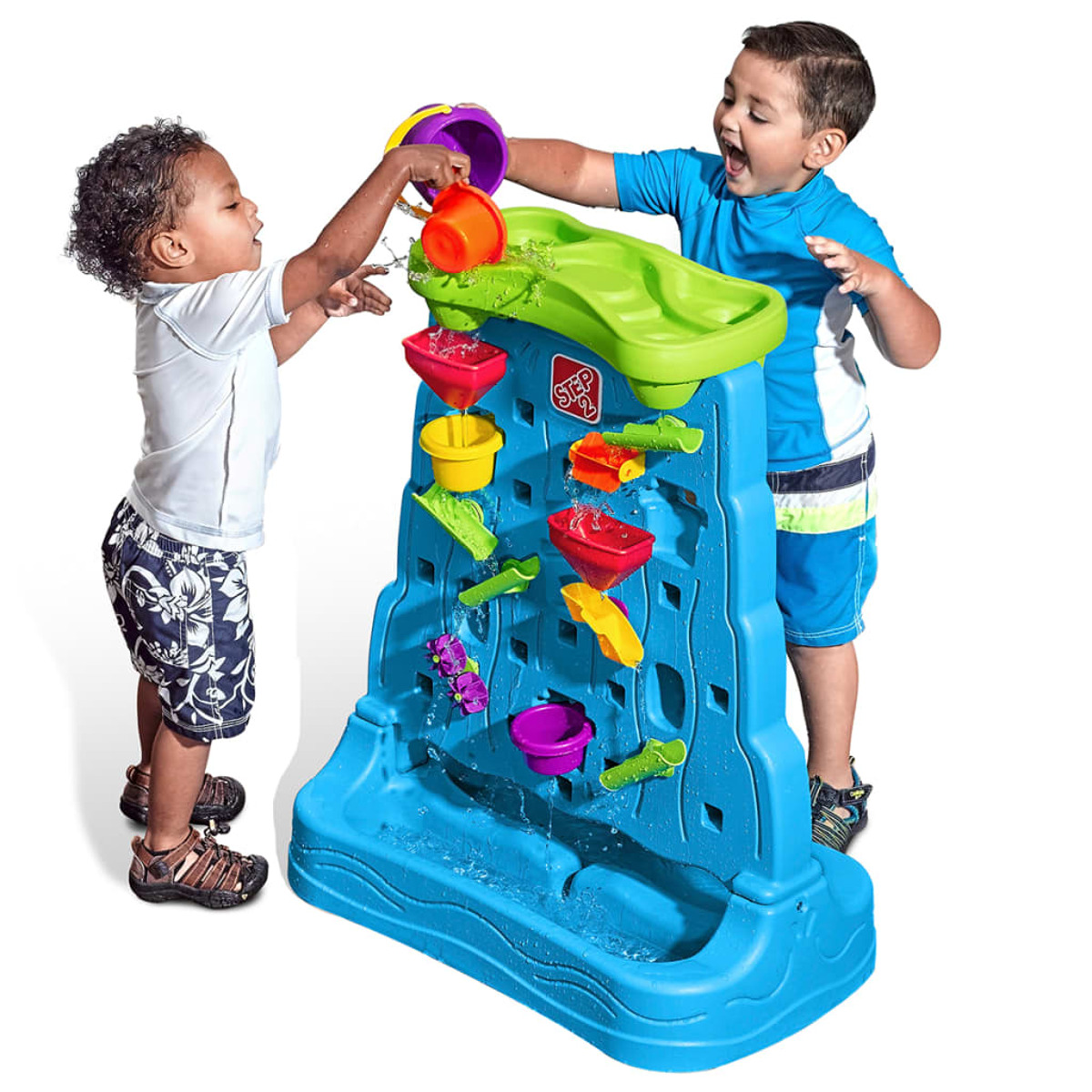 Zwei Kinder spielen mit einem Wassertisch und gießen Wasser hinein.