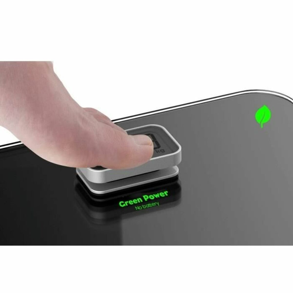 Palec naciska przycisk na czarnej wadze. Waga pokazuje 'kg' i ma symbol zielonego liścia.