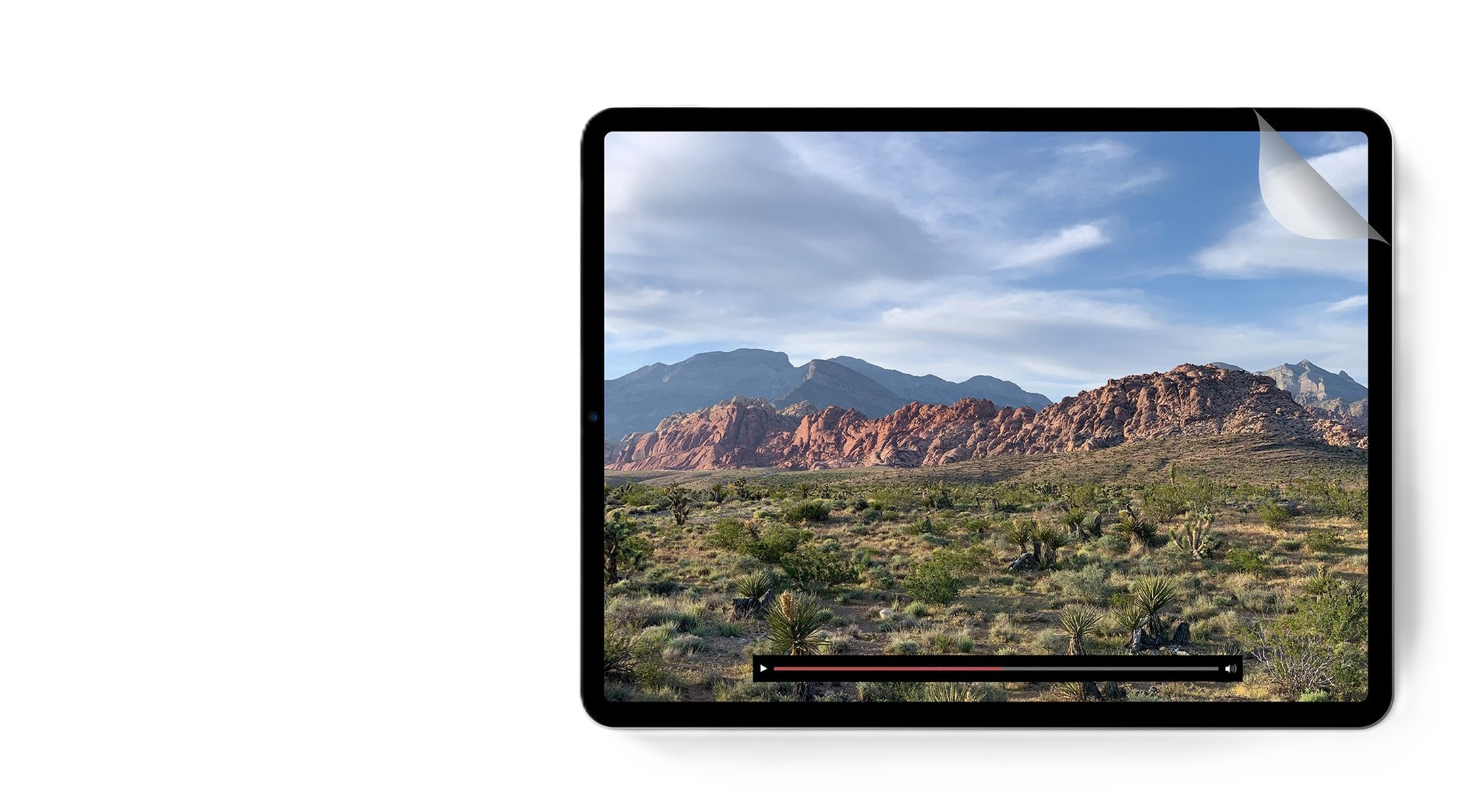Tableta mostrando un vídeo de paisaje, con barra de progreso. La tableta está en una superficie blanca.