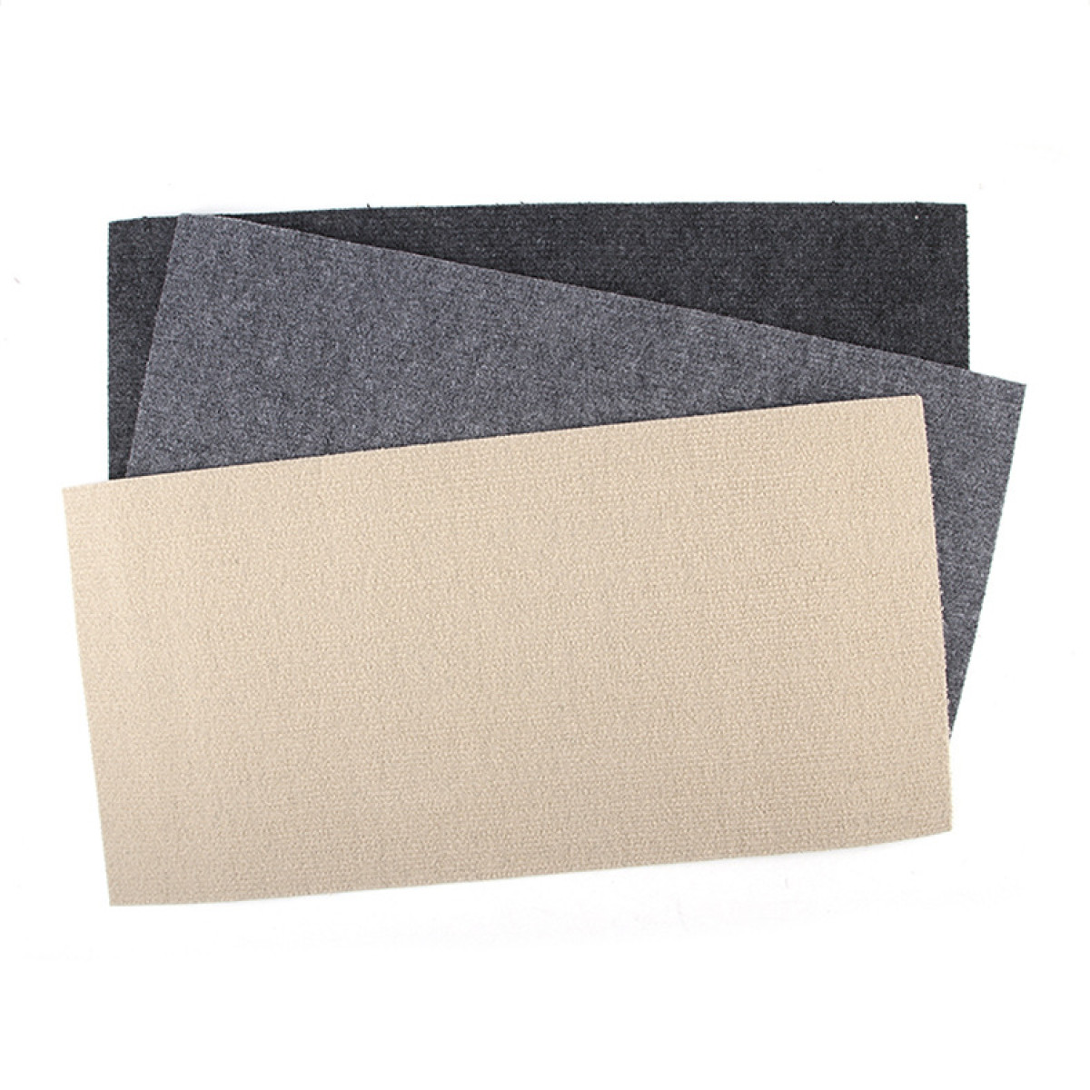 Tres muestras de tela en colores crema, gris y negro sobre una superficie blanca.