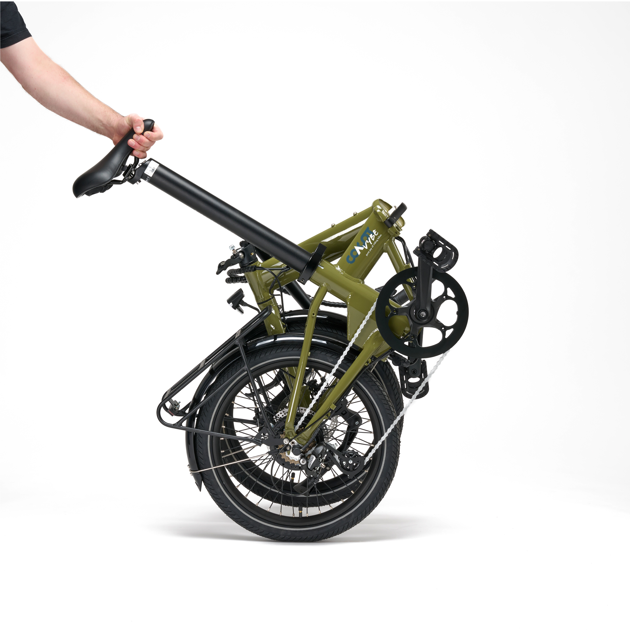 Gefaltetes grünes Fahrrad, das von einer Person gehalten wird, weißer Hintergrund. Das Fahrrad ist gefaltet.