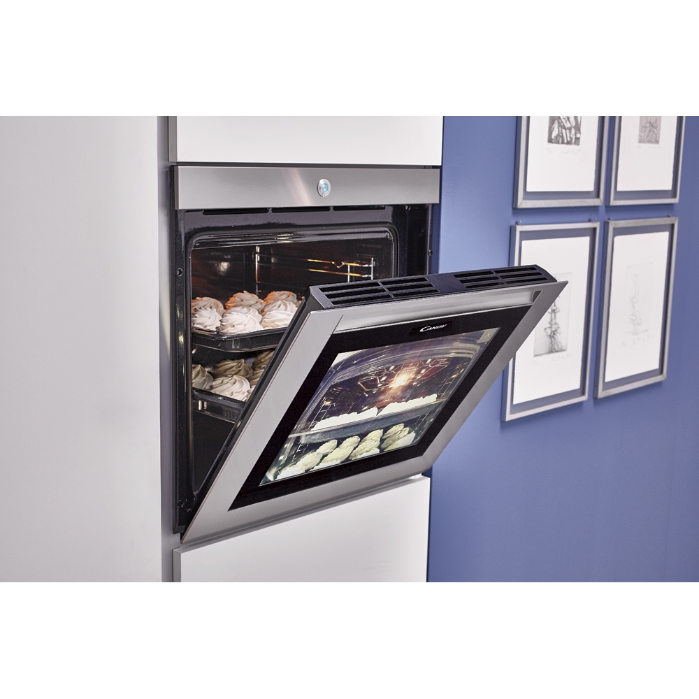 Un forno con la porta aperta, che mostra prodotti da forno all'interno. Lo sfondo include una parete blu.