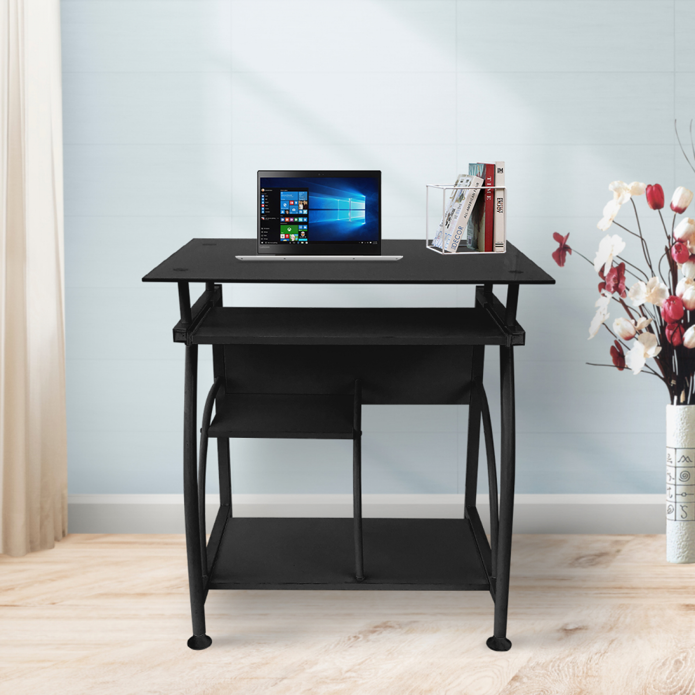 Zwart computerbureau met laptop, pennen en boeken. Witte muur en raam op de achtergrond.