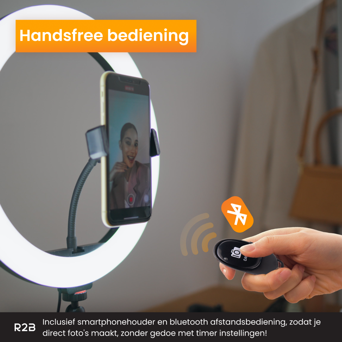 A person holding a remote for a ring light, with a phone attached.