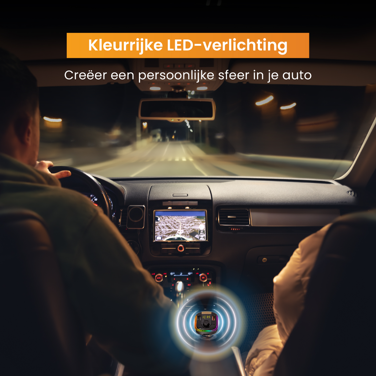 A man driving a car at night. A colorful light reflects on the dashboard.