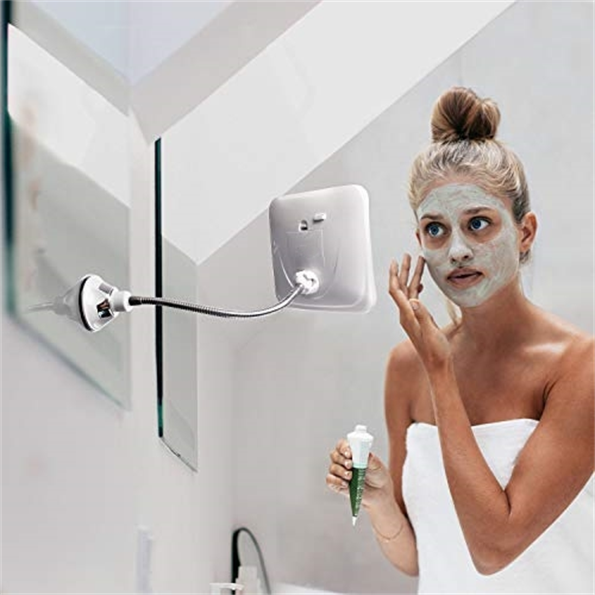 Frau mit Gesichtsmaske schaut in einen Spiegel. Spiegel ist an einem flexiblen Arm befestigt.