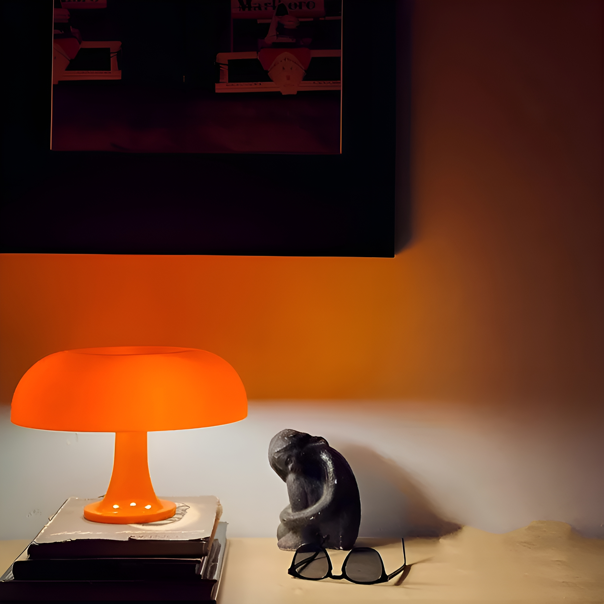 Eine orangefarbene Pilzlampe auf einer weißen Oberfläche. Eine schwarze Skulptur, Bücher und Gläser sind vorhanden.