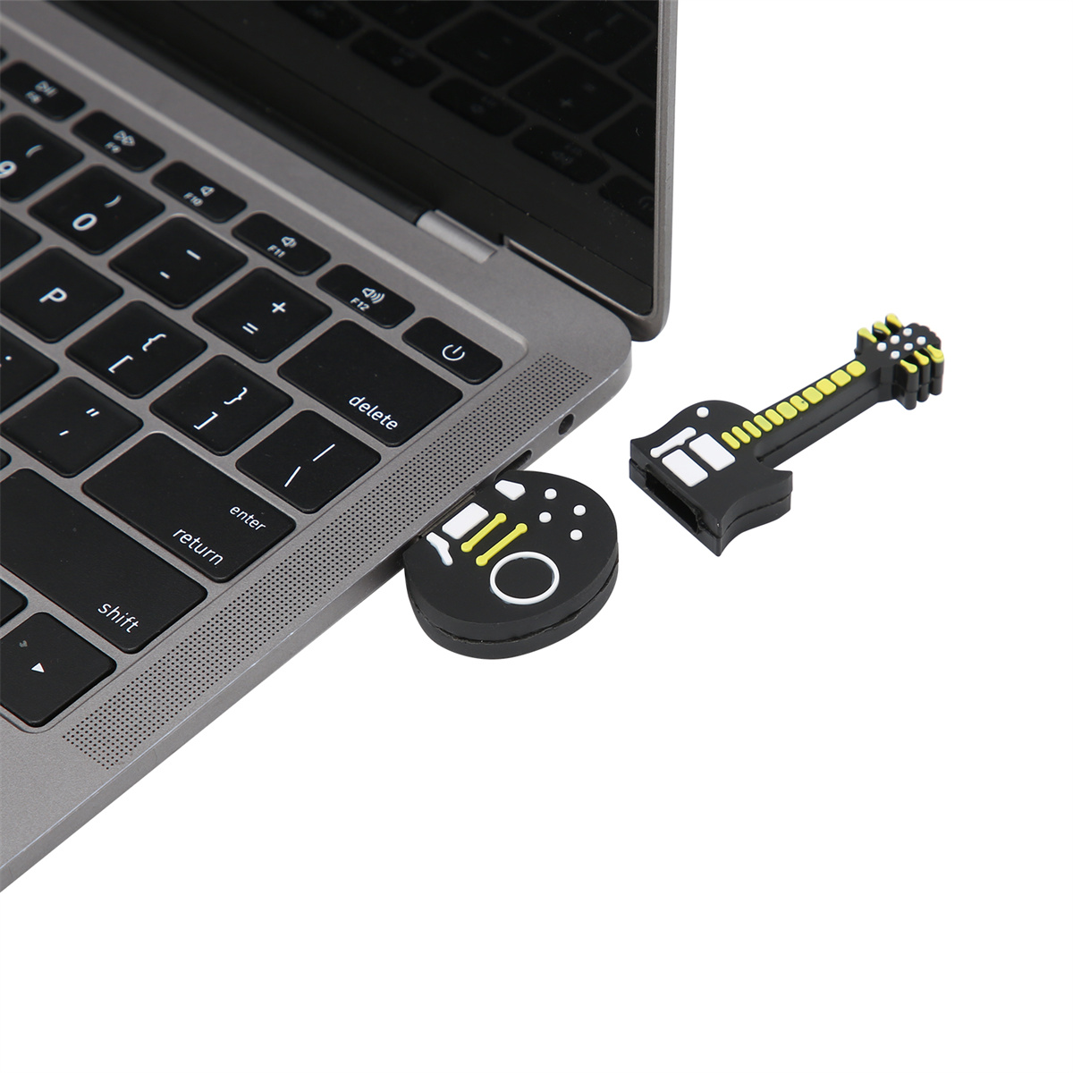 Ein Laptop mit USB-Anschluss. Zwei USB-Laufwerke in Form einer Gitarre und eines Controllers sind eingesteckt.
