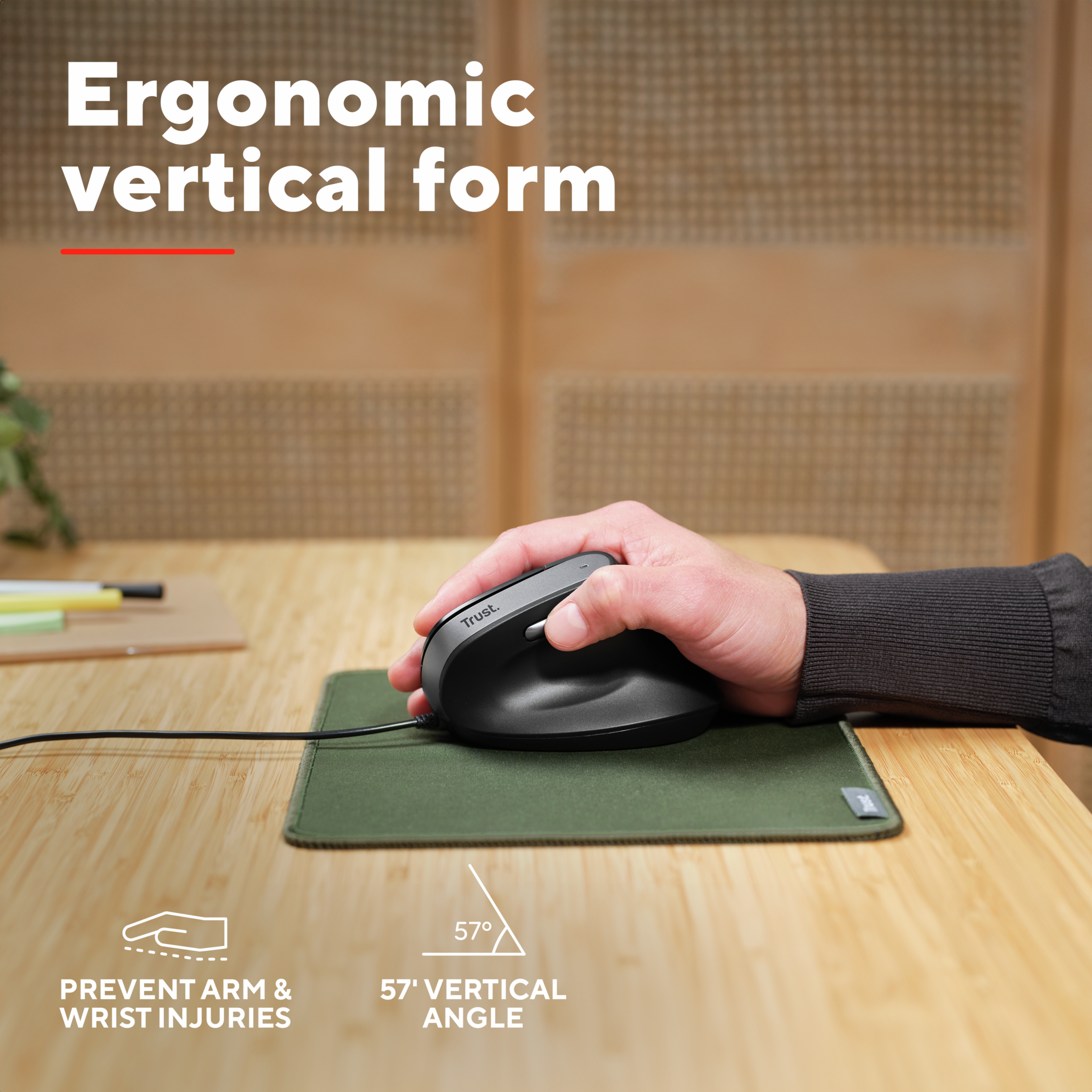 A person's hand using a vertical ergonomic mouse on a green mousepad.