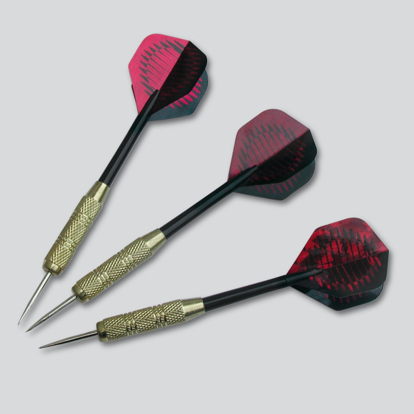 Drie darts met zwarte schachten en rode en zwarte flights. De darts liggen op een grijze ondergrond.