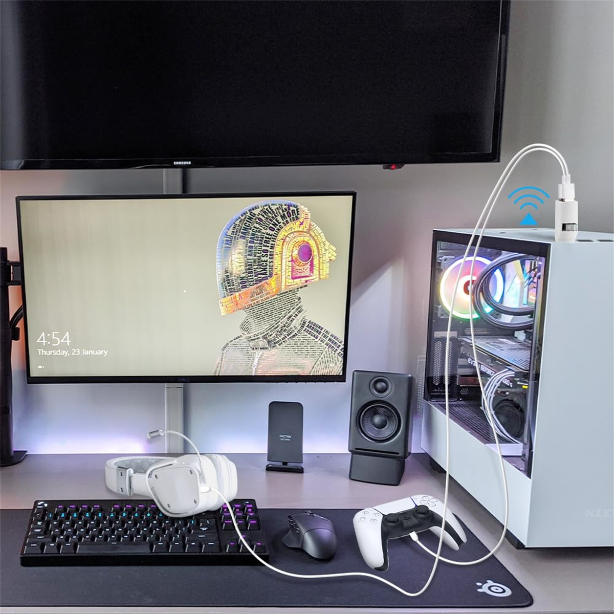 Ein Gaming-Setup mit Computer, Monitor, Tastatur, Maus und Controller. Weißer WLAN-Adapter.