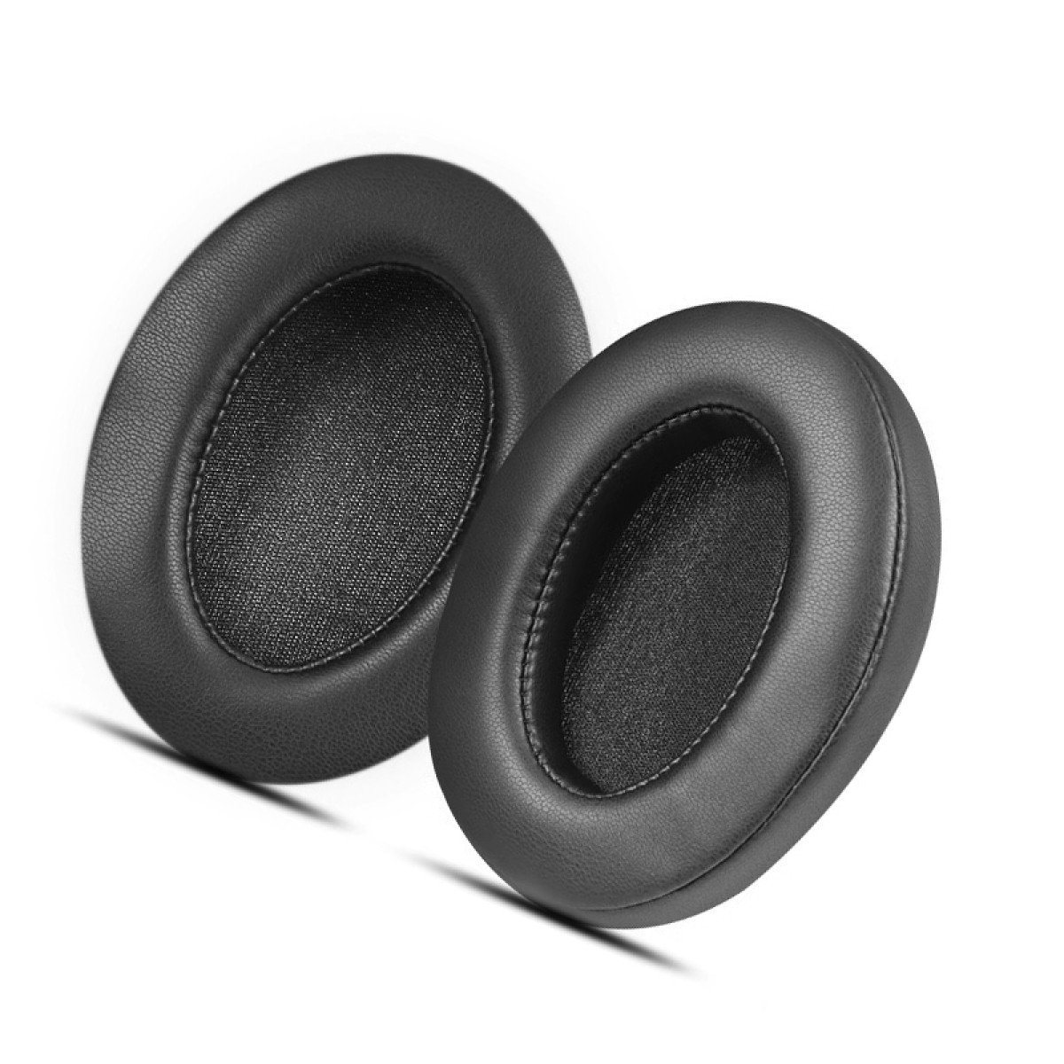 Dwie czarne, owalne poduszki na uszy na białym tle. Są miękkie i pluszowe.