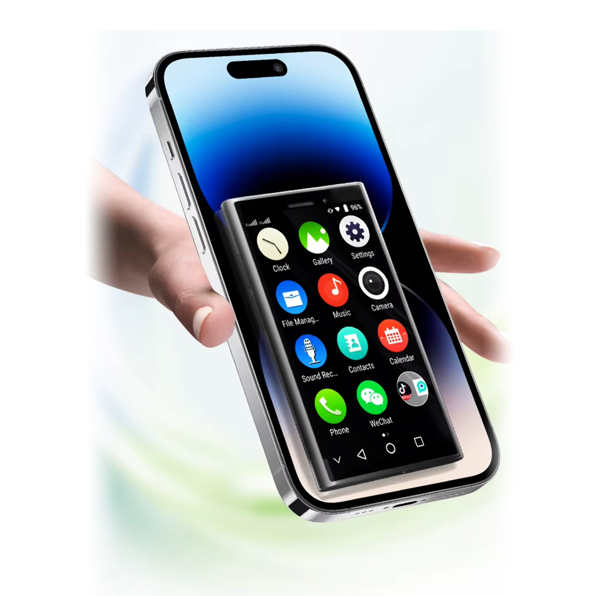 Ręka trzyma smartfon, na ekranie mniejszy telefon. Widoczne ikony aplikacji.