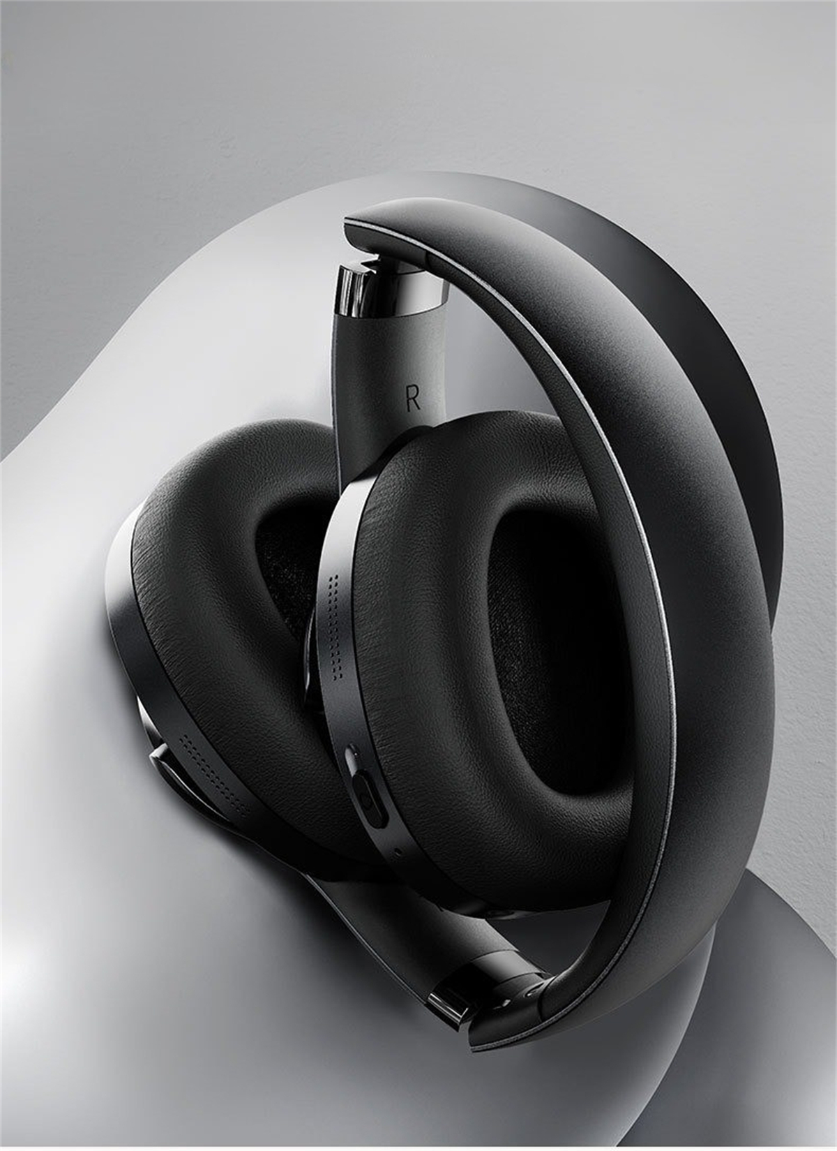 Gefaltete schwarze Kopfhörer. Over-Ear-Design, gepolsterte Ohrmuscheln, silberne Akzente.