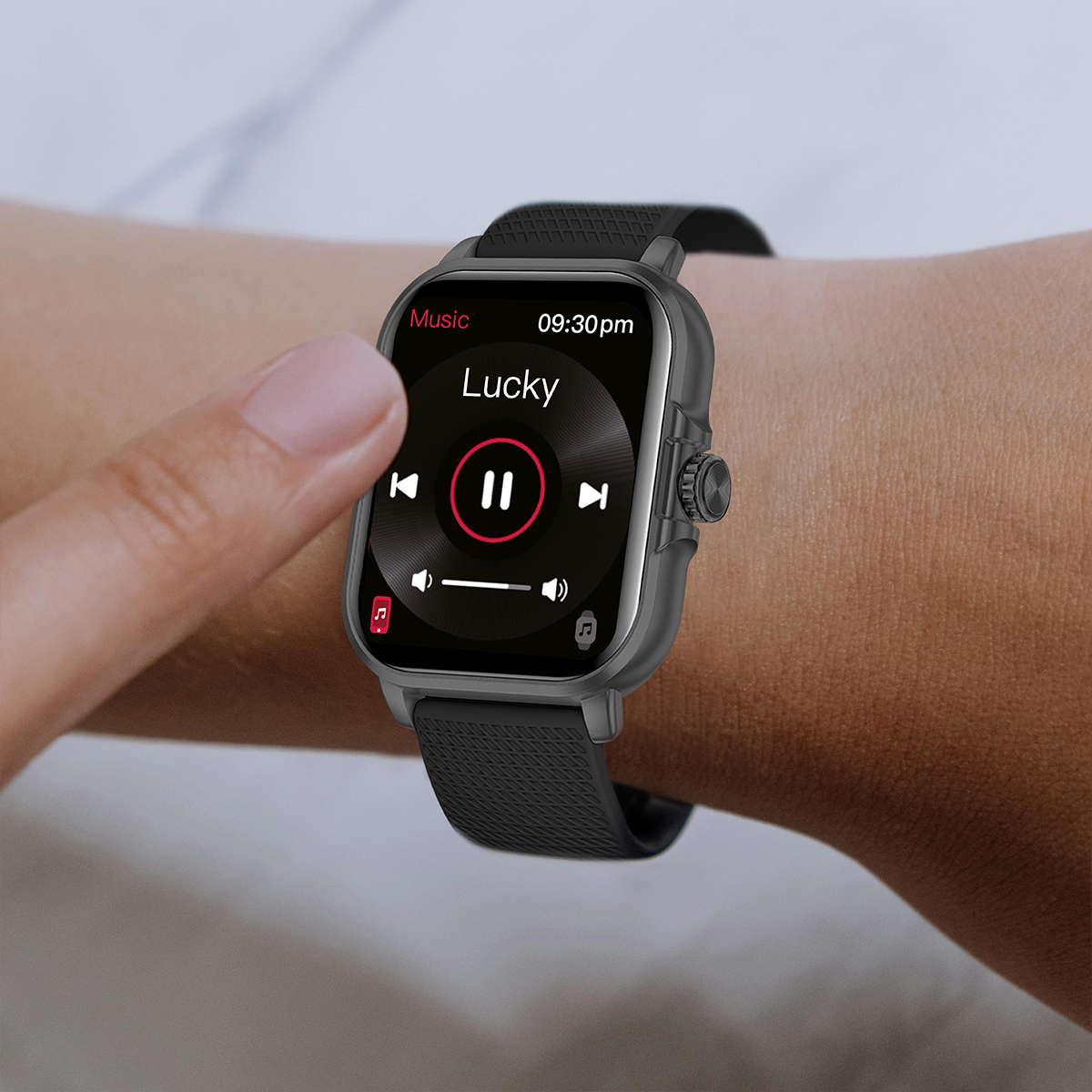 Nadgarstek osoby ze smartwatchem. Zegarek wyświetla interfejs muzyczny z przyciskiem pauzy.