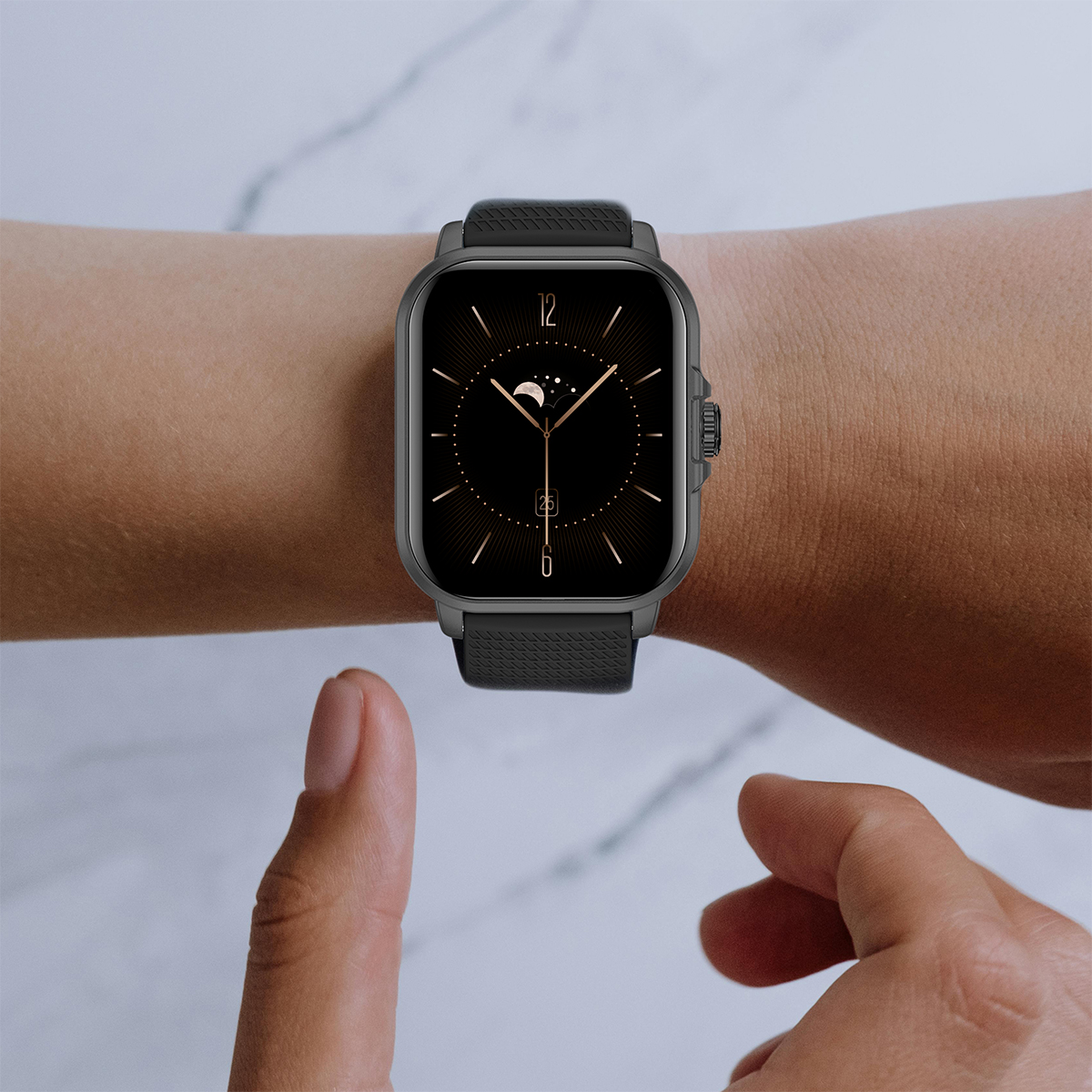 Nadgarstek osoby z czarnym smartwatchem. Zegarek wyświetla księżyc i datę.
