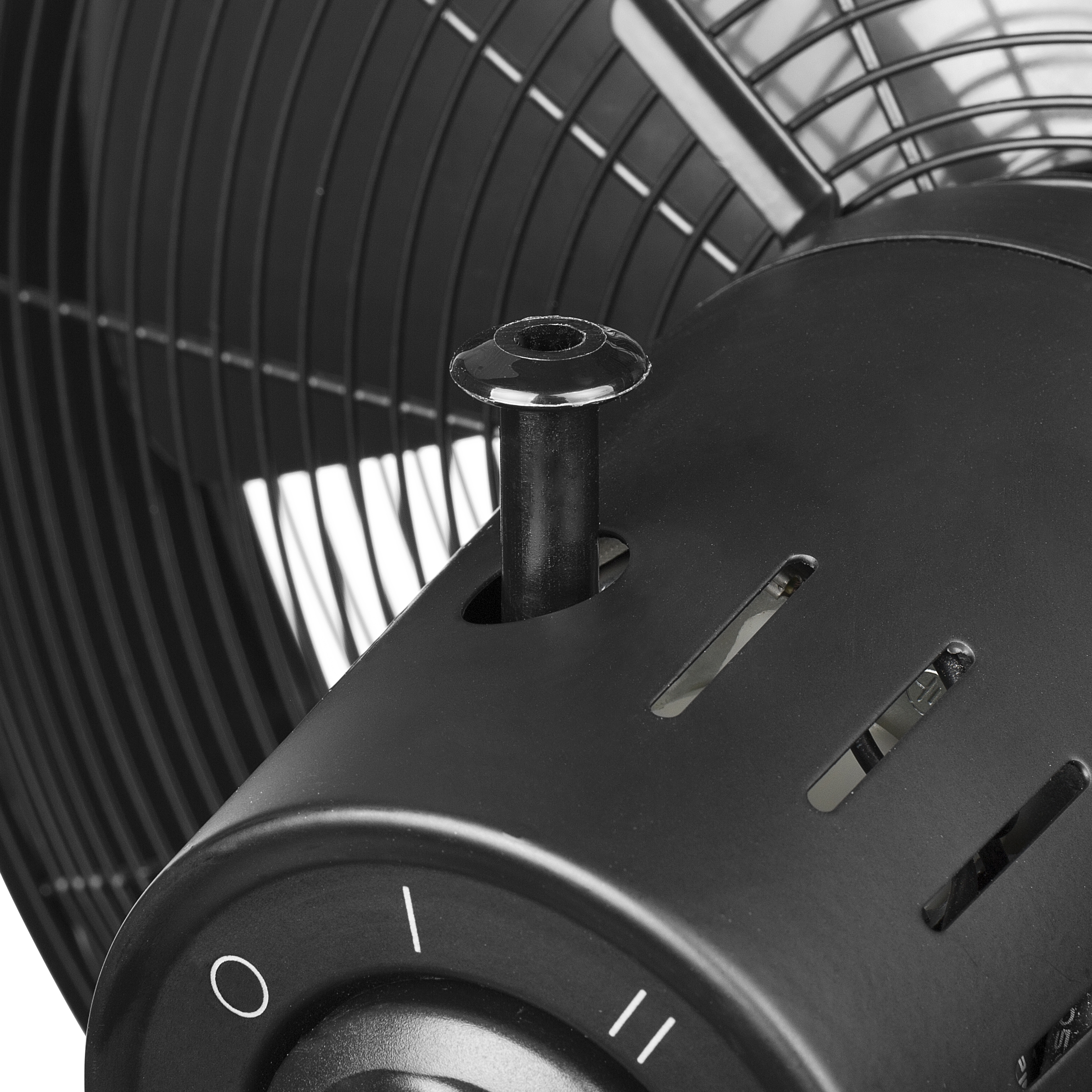 Primer plano de un ventilador negro. Muestra el motor del ventilador, con la perilla de control y las rejillas visibles. Color negro.
