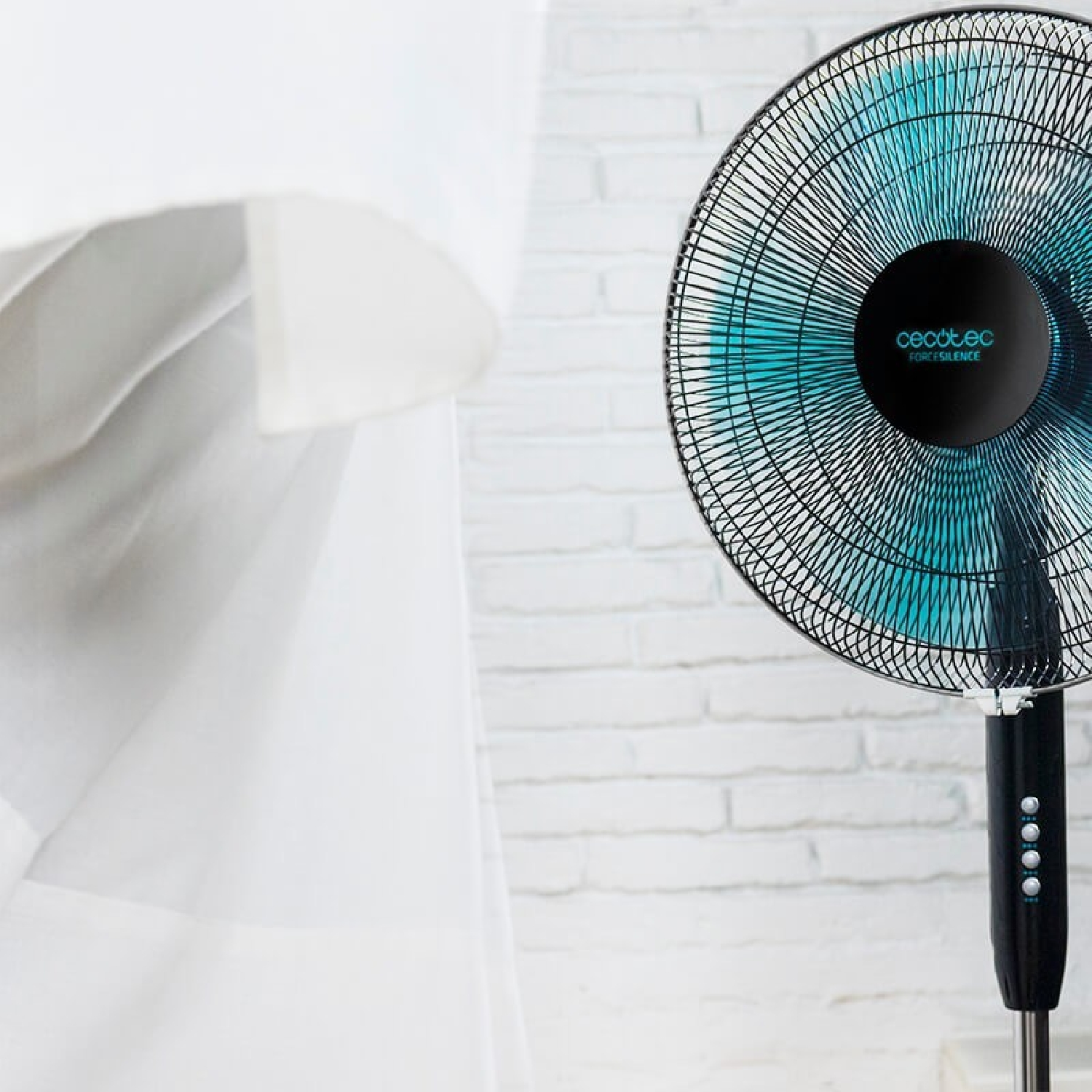 Una pared blanca, un ventilador y una cortina blanca. El ventilador tiene aspas azules y una jaula negra.