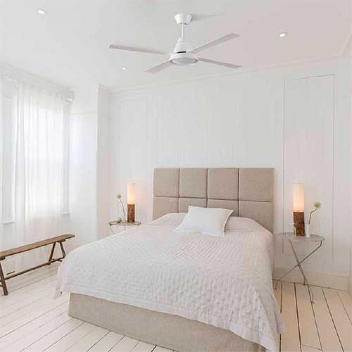 A bedroom with a white ceiling fan, bed, and white walls and floors.