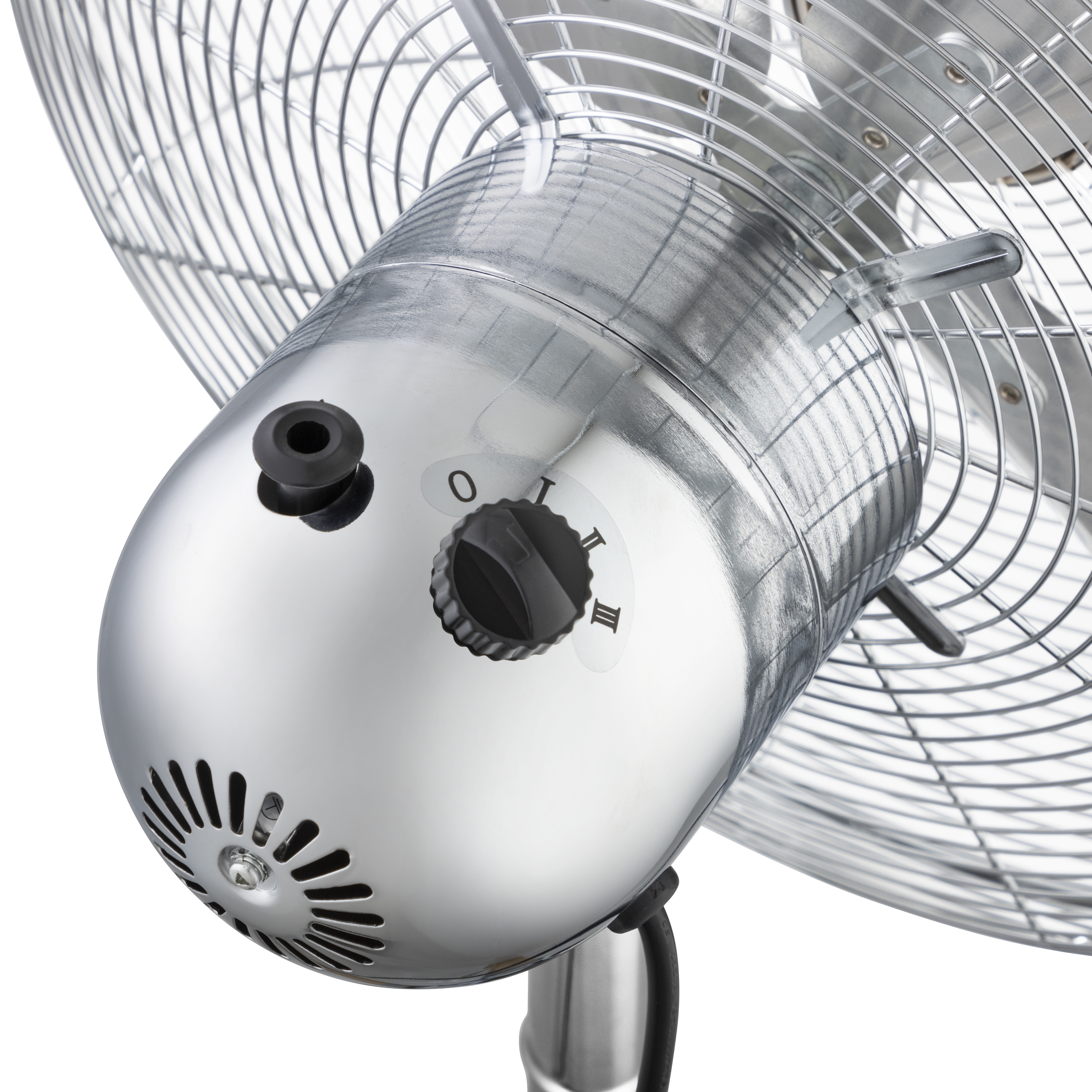 Primo piano di un ventilatore cromato con un quadrante etichettato 0, I, II, III. Le pale del ventilatore sono visibili.