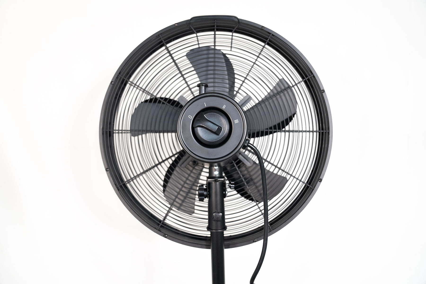 Czarny wentylator stojący z okrągłą kratką i stojakiem. Wentylator jest na białym tle.