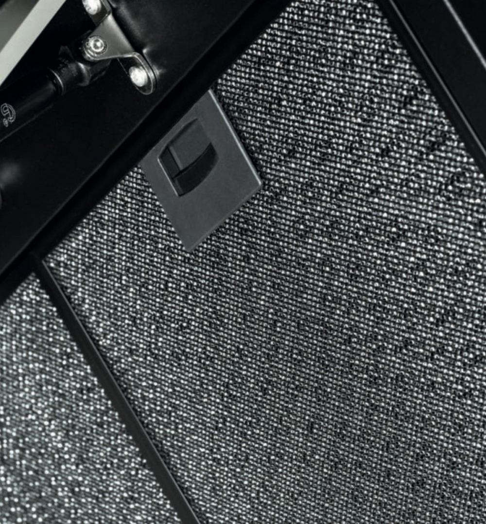 Primo piano di un filtro nero della cappa con una rete metallica a motivi.