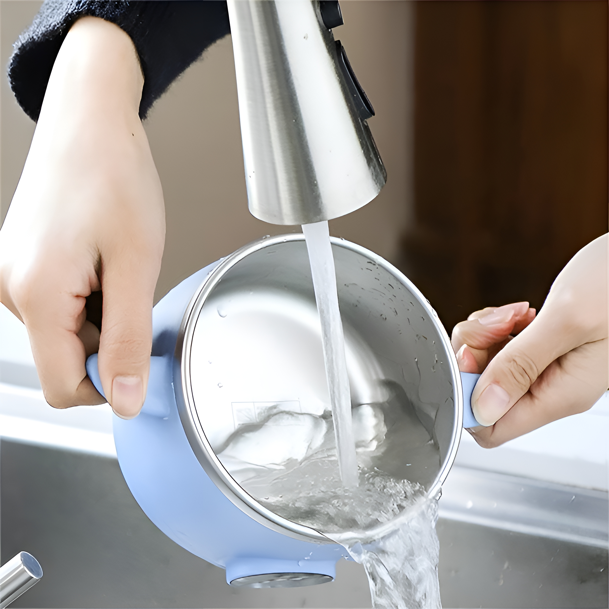 Hände waschen eine blaue Schüssel. Wasser gießt in eine Edelstahlschüssel.