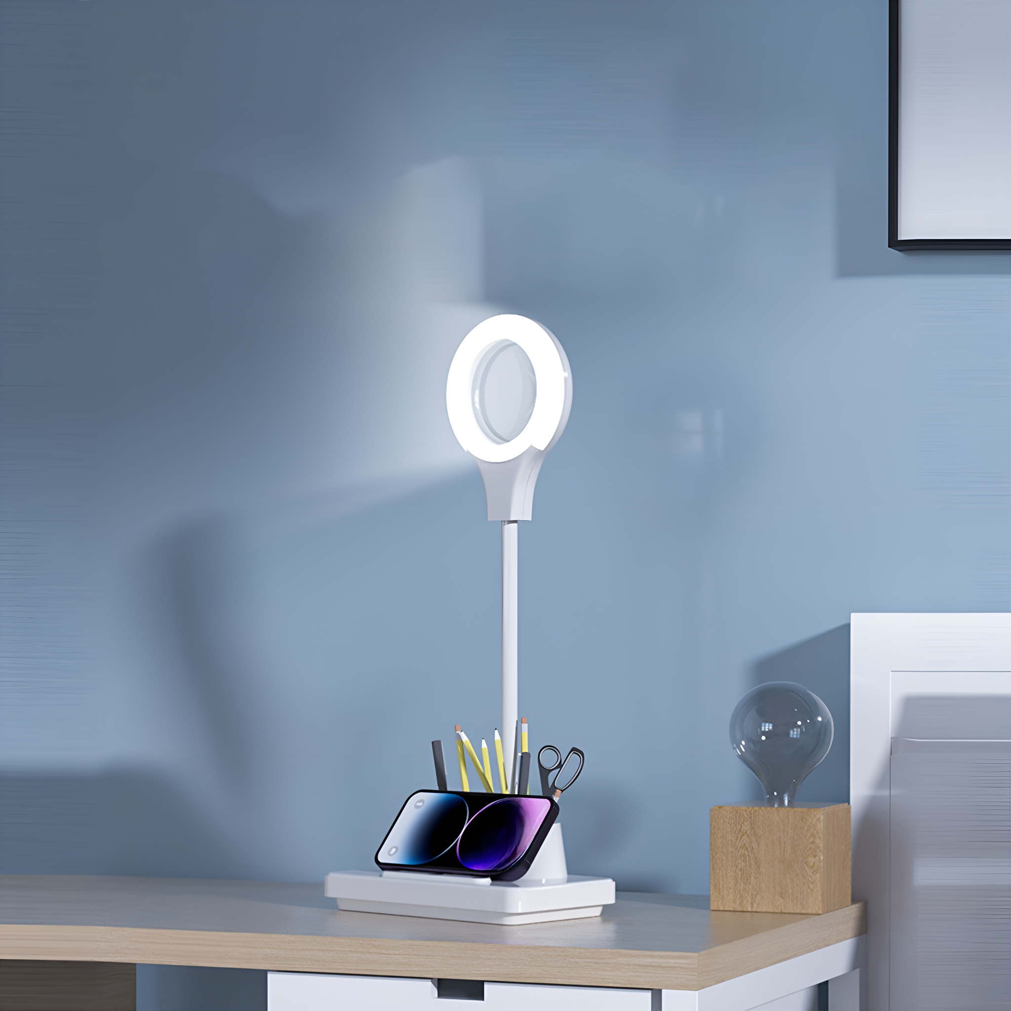 Ein Schreibtisch mit Ringlicht, Telefon, Stiften und einer kleinen Glühbirne.