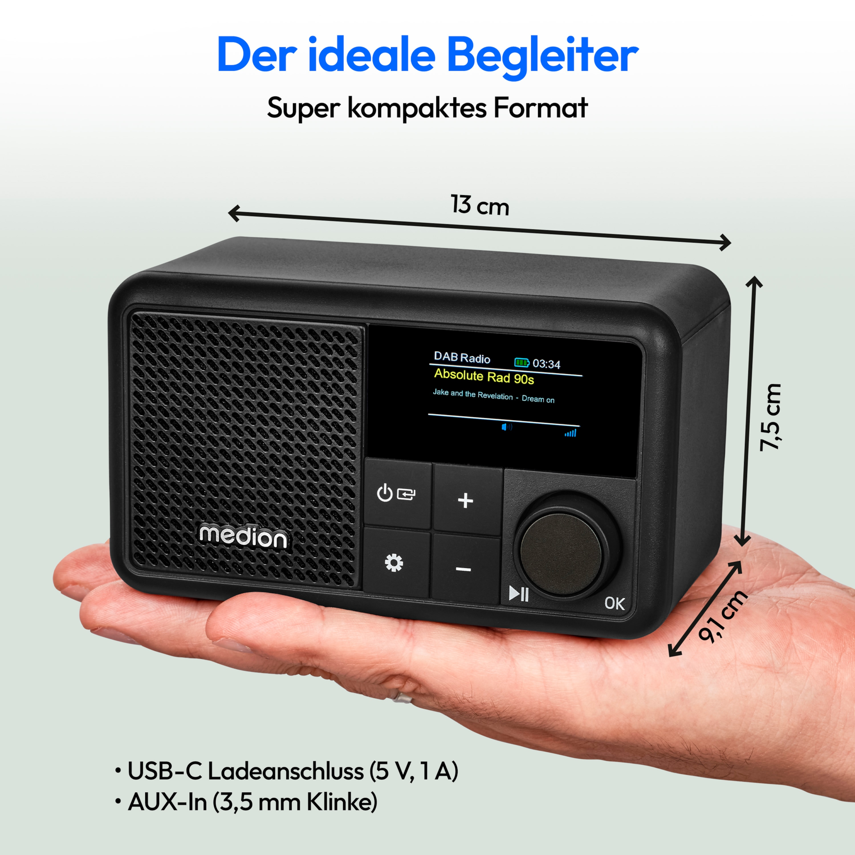 A small black radio with a display screen, buttons, and a hand holding it.