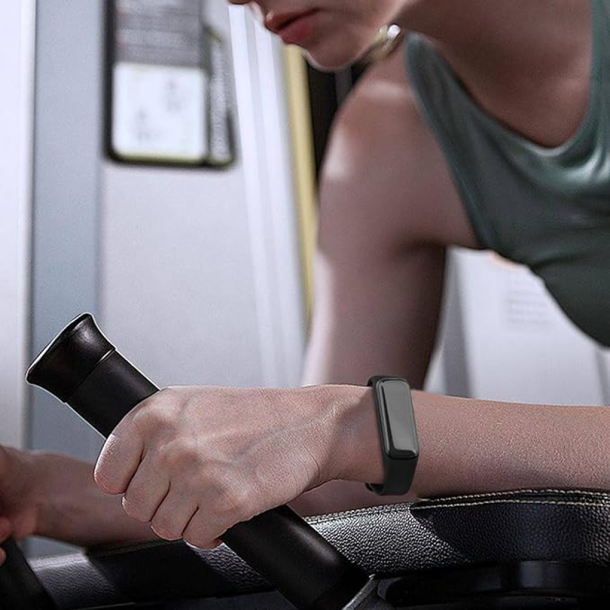 Osoba nosząca czarny tracker fitness na nadgarstku, ćwicząca.