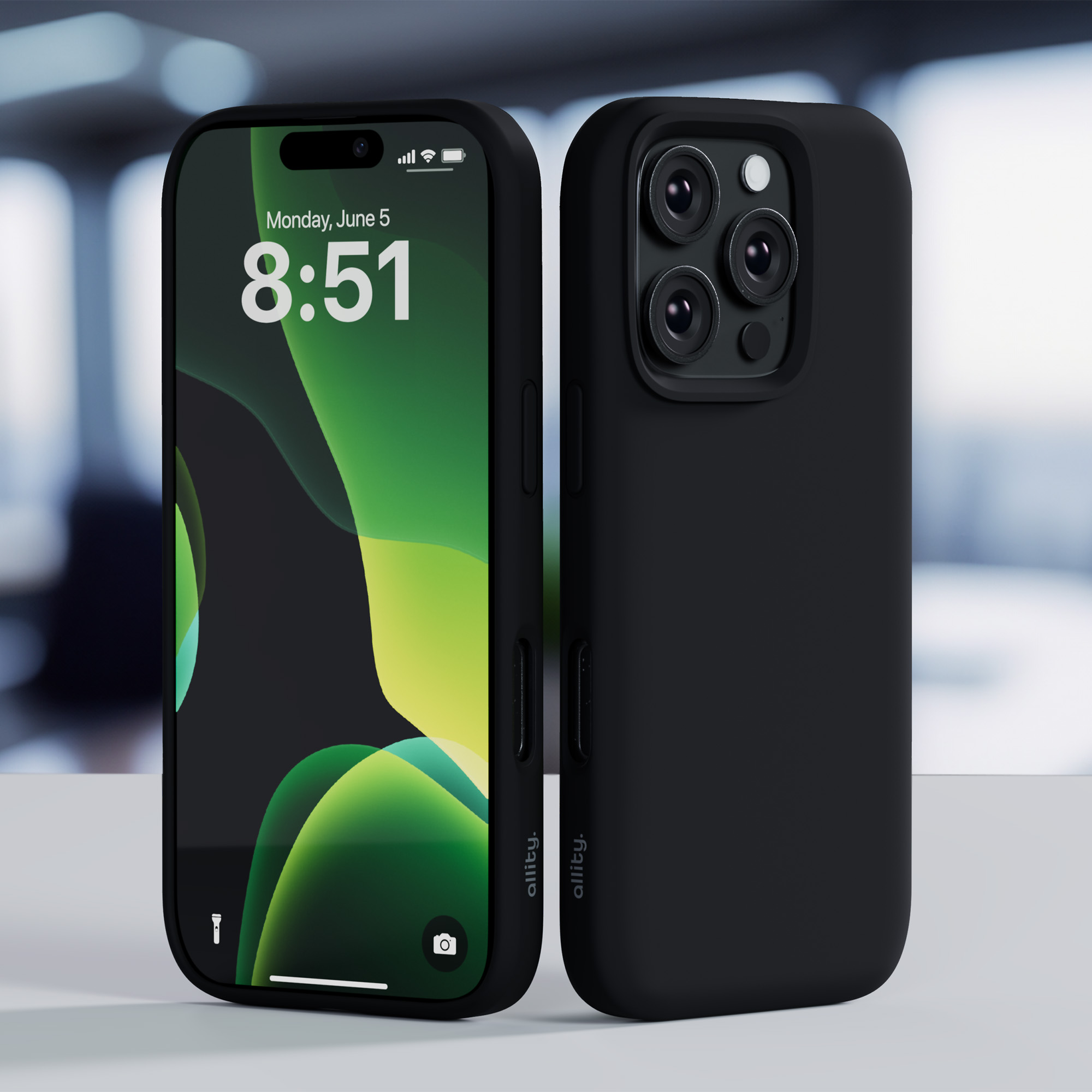 Czarny iPhone w etui. Na stole, wyświetlający datę i godzinę. Rozmyte tło.