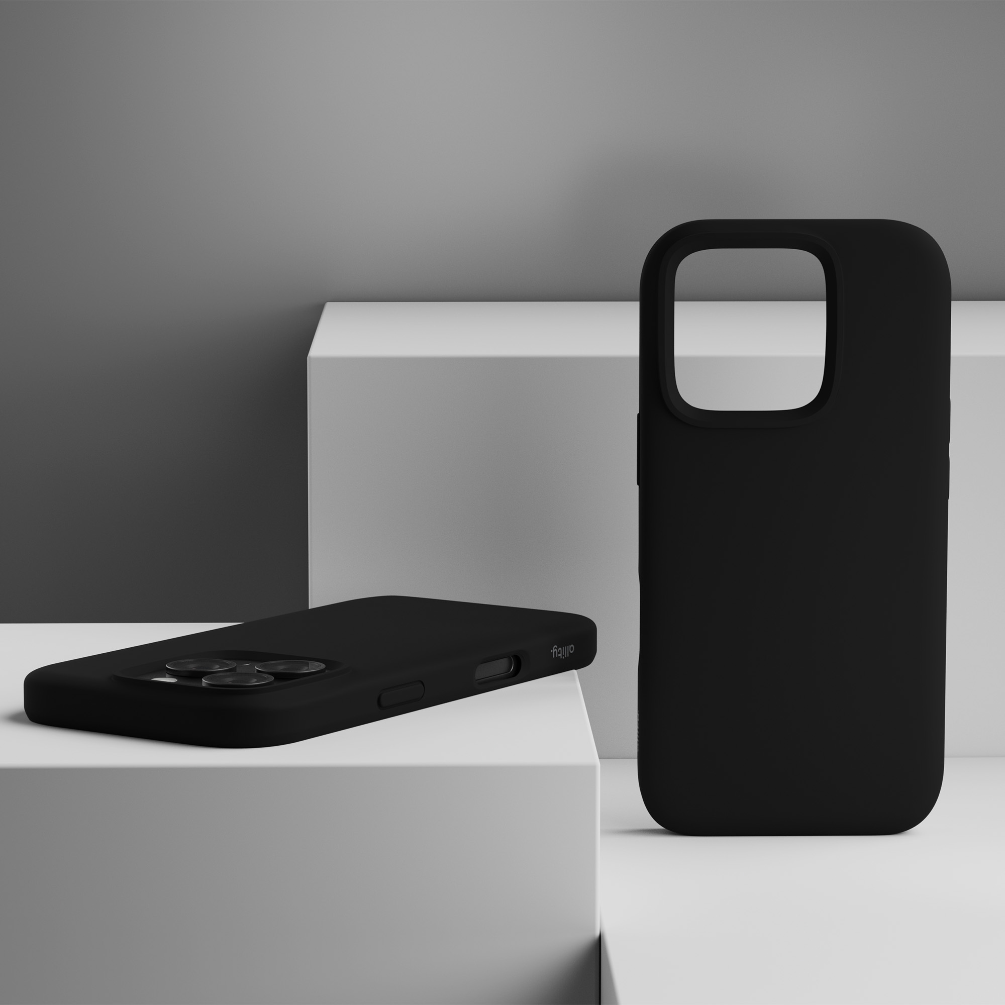 Dwa czarne etui na telefon na białych platformach na szarym tle, prezentujące elegancki design.