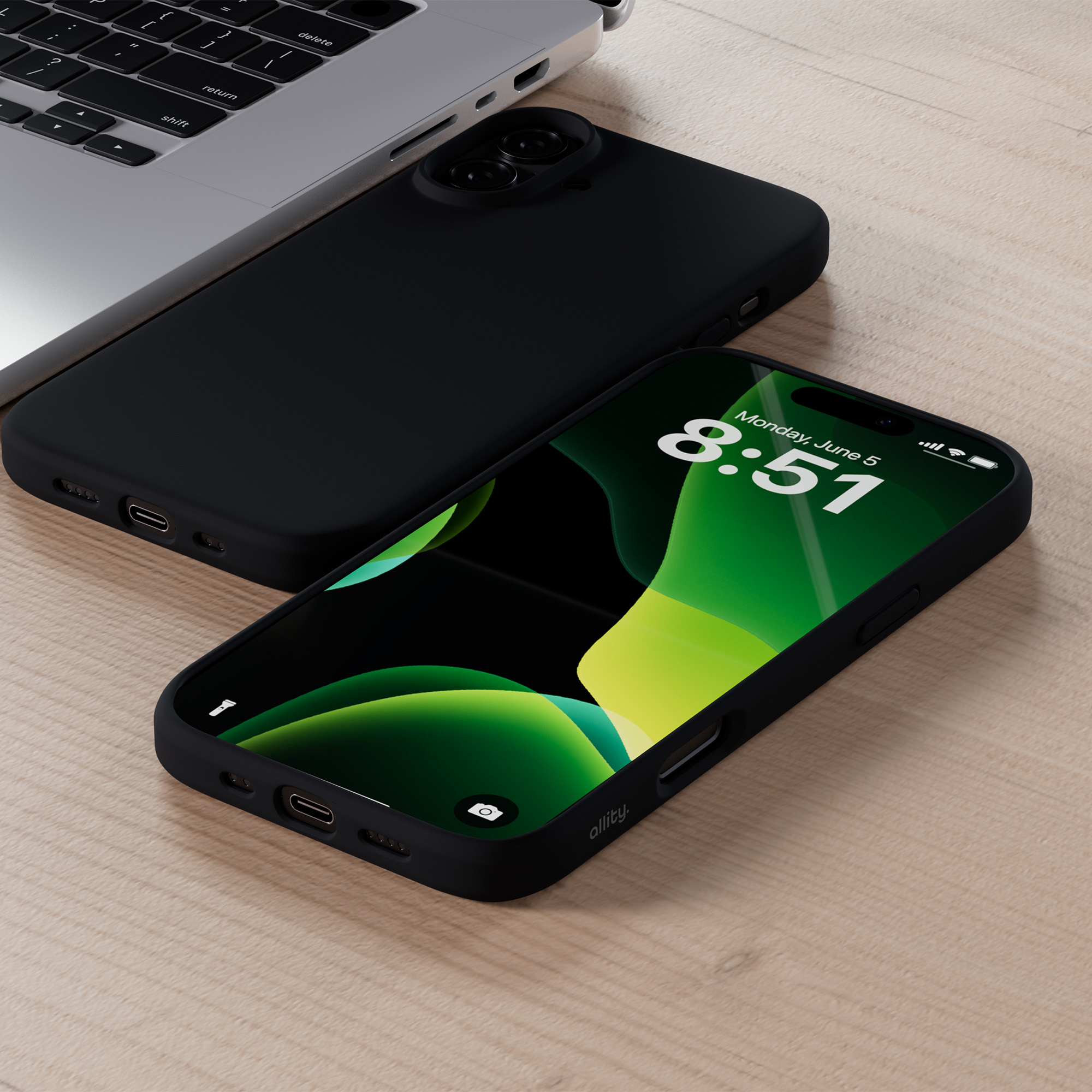 Czarny telefon z wyświetlaniem czasu, obok laptopa. Pokazano czarne etui na telefon.